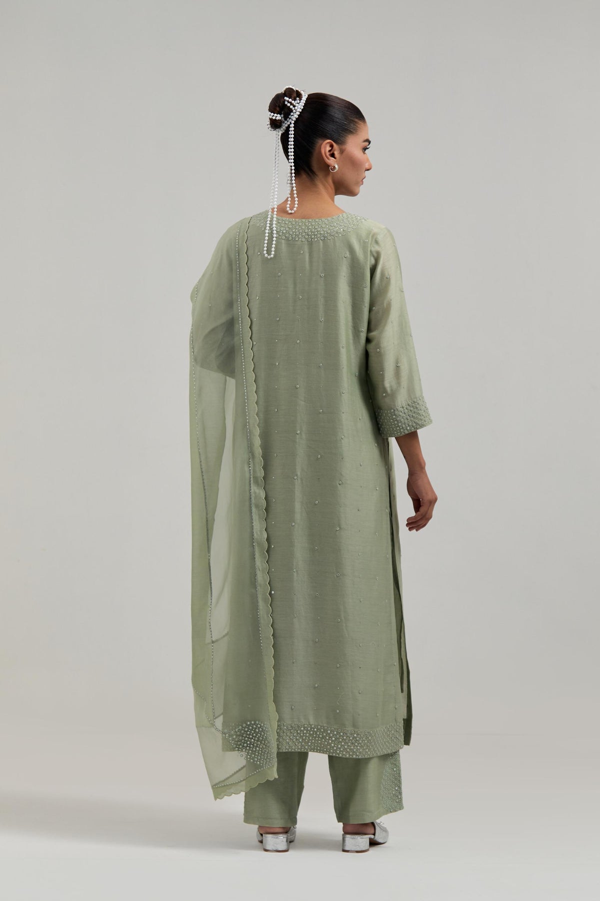 Green silk Chanderi straight kurta set with hand-embroidered mirror at the neck, hem and sleeves, highlighted with scattered silver sequin and mirror embellishments all-over.