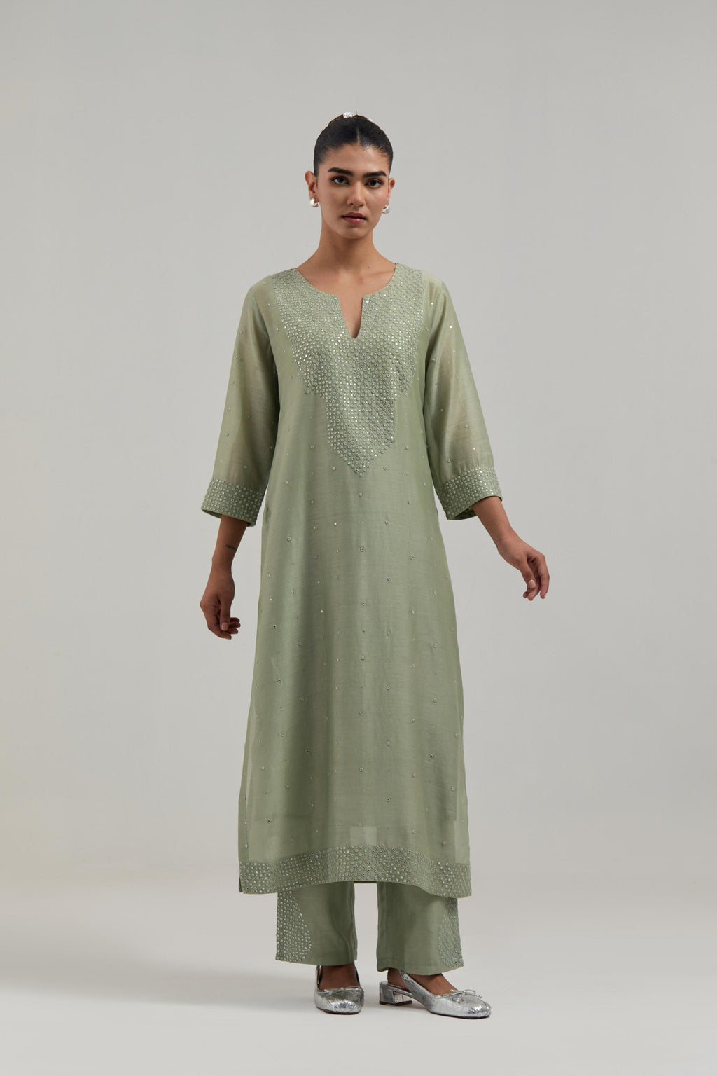 Green silk Chanderi straight kurta set with hand-embroidered mirror at the neck, hem and sleeves, highlighted with scattered silver sequin and mirror embellishments all-over.