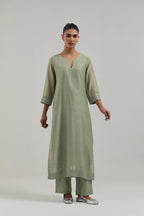 Green silk Chanderi straight kurta set with hand-embroidered mirror at the neck, hem and sleeves, highlighted with scattered silver sequin and mirror embellishments all-over.