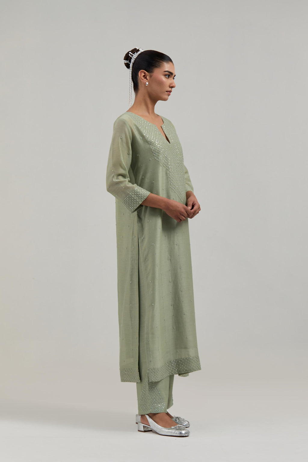 Green silk Chanderi straight kurta set with hand-embroidered mirror at the neck, hem and sleeves, highlighted with scattered silver sequin and mirror embellishments all-over.