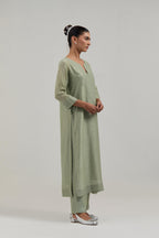 Green silk Chanderi straight kurta set with hand-embroidered mirror at the neck, hem and sleeves, highlighted with scattered silver sequin and mirror embellishments all-over.