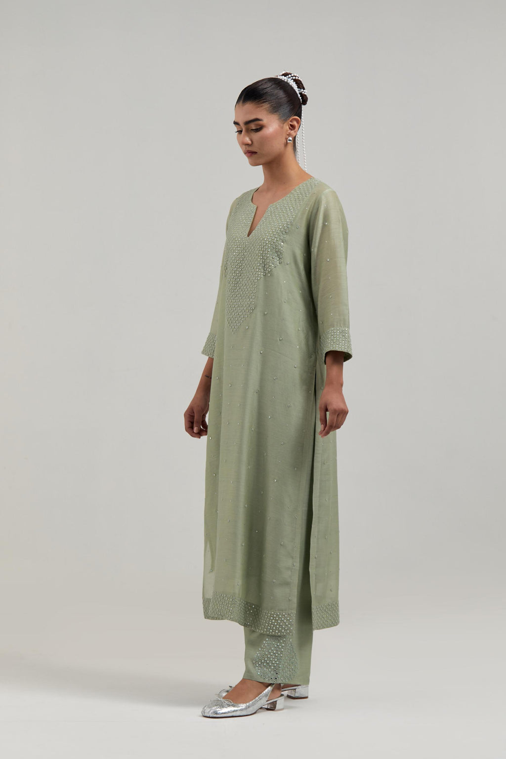 Green silk Chanderi straight kurta set with hand-embroidered mirror at the neck, hem and sleeves, highlighted with scattered silver sequin and mirror embellishments all-over.