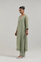 Green silk Chanderi straight kurta set with hand-embroidered mirror at the neck, hem and sleeves, highlighted with scattered silver sequin and mirror embellishments all-over.