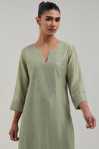 Green silk Chanderi straight kurta set with hand-embroidered mirror at the neck, hem and sleeves, highlighted with scattered silver sequin and mirror embellishments all-over.
