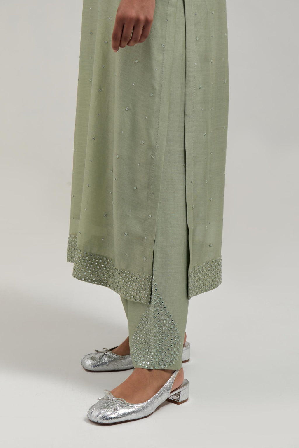 Green silk Chanderi straight kurta set with hand-embroidered mirror at the neck, hem and sleeves, highlighted with scattered silver sequin and mirror embellishments all-over.