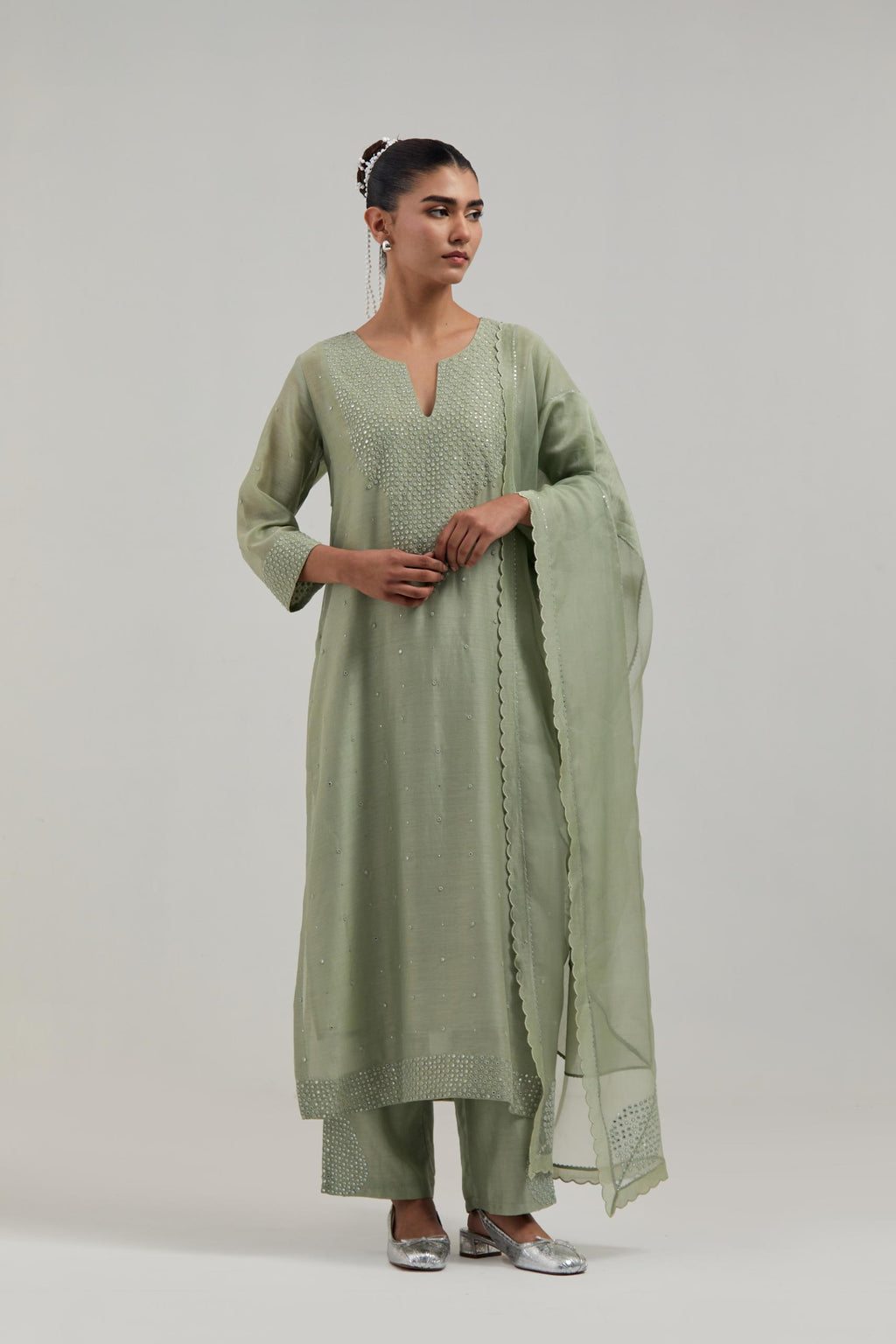 Green silk Chanderi straight kurta set with hand-embroidered mirror at the neck, hem and sleeves, highlighted with scattered silver sequin and mirror embellishments all-over.