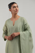 Green silk Chanderi straight kurta set with hand-embroidered mirror at the neck, hem and sleeves, highlighted with scattered silver sequin and mirror embellishments all-over.