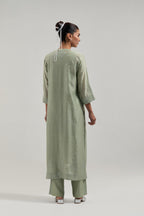 Green silk Chanderi straight kurta set with hand-embroidered mirror at the neck, borders running along the hem and sleeve edges, and scattered silver sequin and mirror embellishments all-over.