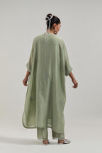 Green silk Chanderi long kaftan with hand-embroidered mirror and sequins at the neck and diamond motifs along the sides, paired with Green silk Chanderi straight pants with narrow organza scalloped hem and hand-embroidered diamond motifs with delicate.