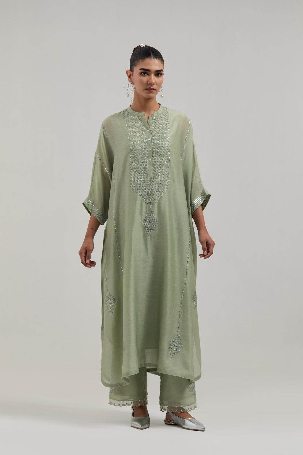 Green silk Chanderi long kaftan with hand-embroidered mirror and sequins at the neck and diamond motifs along the sides, paired with Green silk Chanderi straight pants with narrow organza scalloped hem and hand-embroidered diamond motifs with delicate.