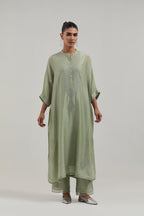 Green silk Chanderi long kaftan with hand-embroidered mirror and sequins at the neck and diamond motifs along the sides, paired with Green silk Chanderi straight pants with narrow organza scalloped hem and hand-embroidered diamond motifs with delicate.