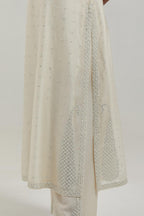 Off white silk Chanderi straight kurta set with hand-embroidered paisley motifs with delicate mirror and sequins work at neck, hem, and sleeves, with narrow borders along the edges.