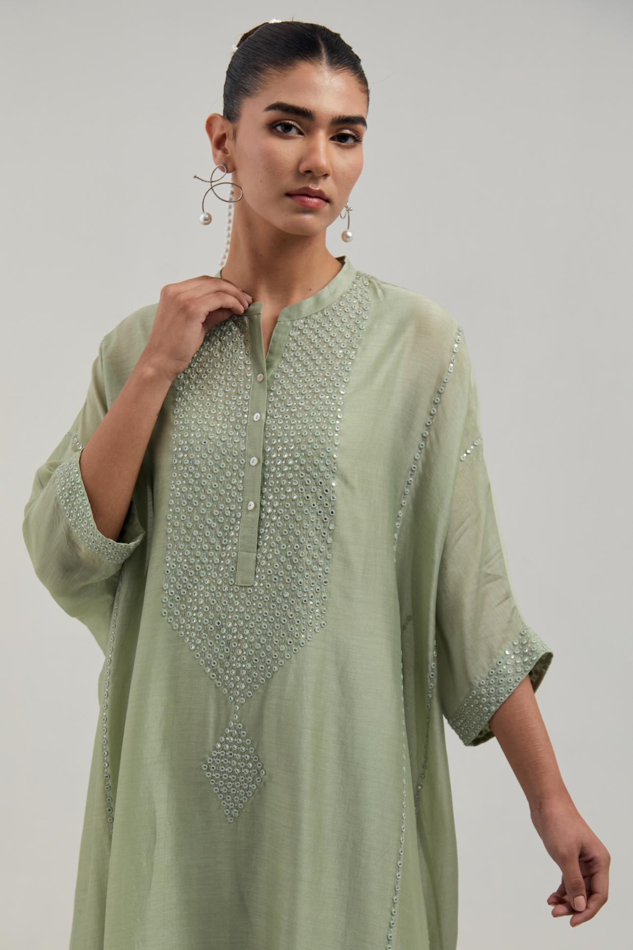 Green silk Chanderi long kaftan with hand-embroidered mirror and sequins at the neck and diamond motifs along the sides, paired with Green silk Chanderi straight pants with narrow organza scalloped hem and hand-embroidered diamond motifs with delicate.