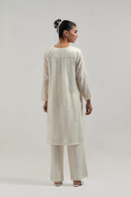 Off white Silk Chanderi short kurta set with hand-embroidered paisley motifs with delicate mirror and sequins work all-over the kurta.