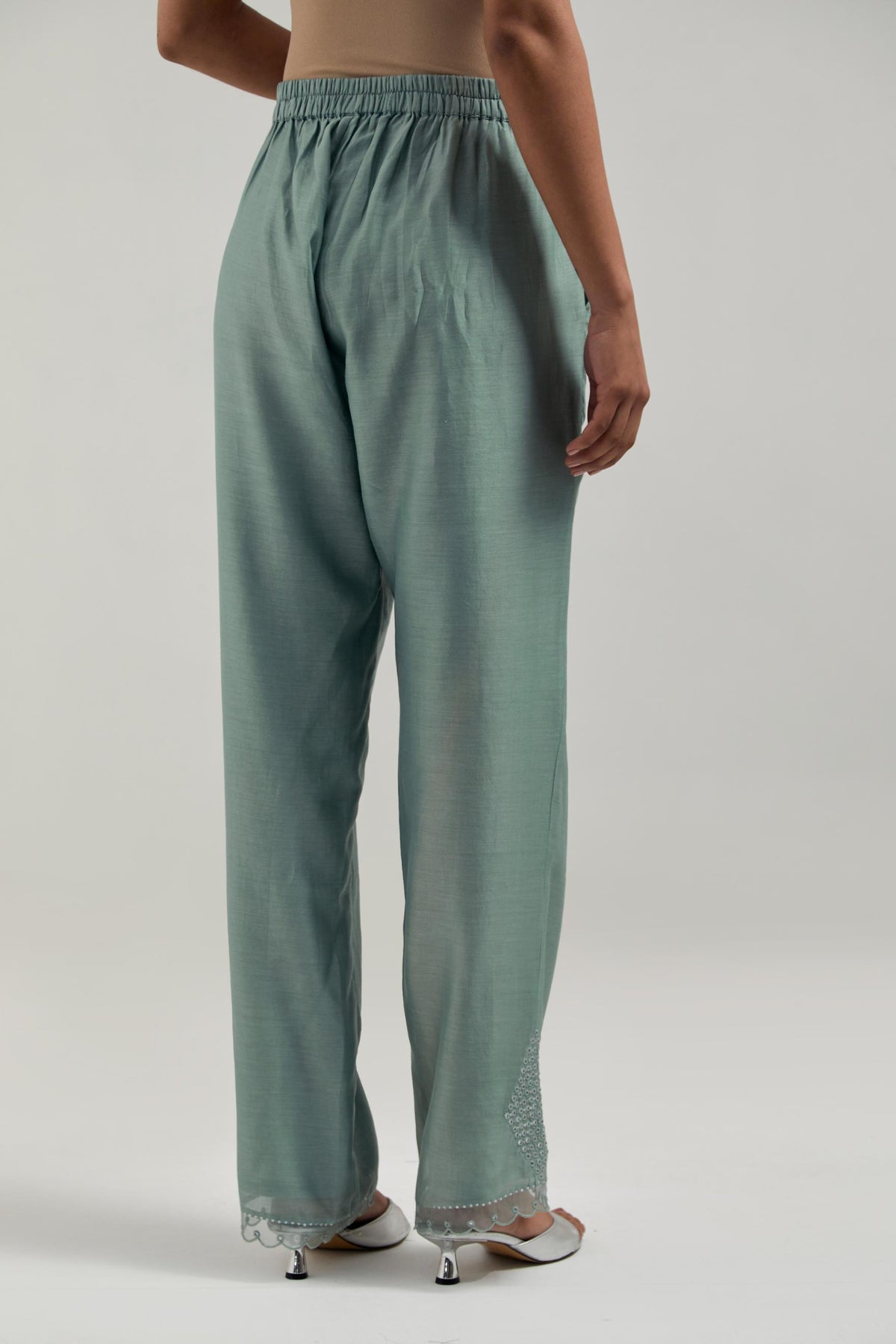 Blue silk Chanderi straight pants with narrow organza scalloped hem and hand-embroidered diamond motifs with delicate mirror & sequins work at the sides.