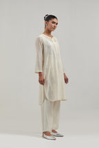 Off white Silk Chanderi short kurta set with hand-embroidered paisley motifs with delicate mirror and sequins work all-over the kurta.