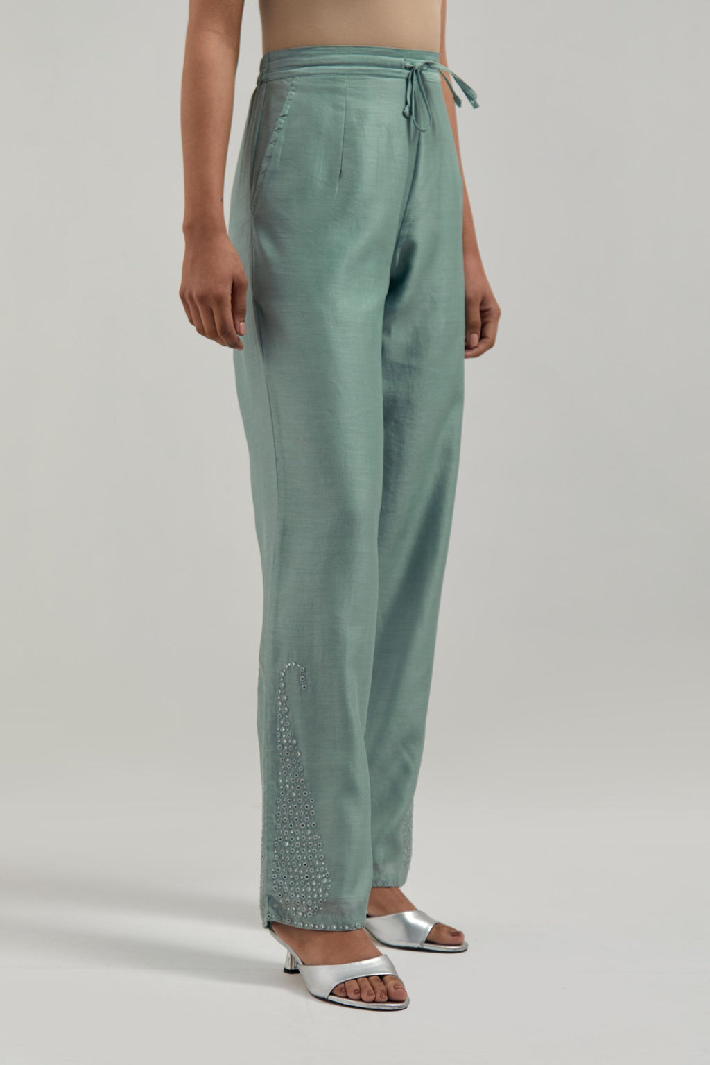 Blue silk Chanderi pants with hand-embroidered paisley motifs with delicate mirror and sequins work at the hem.