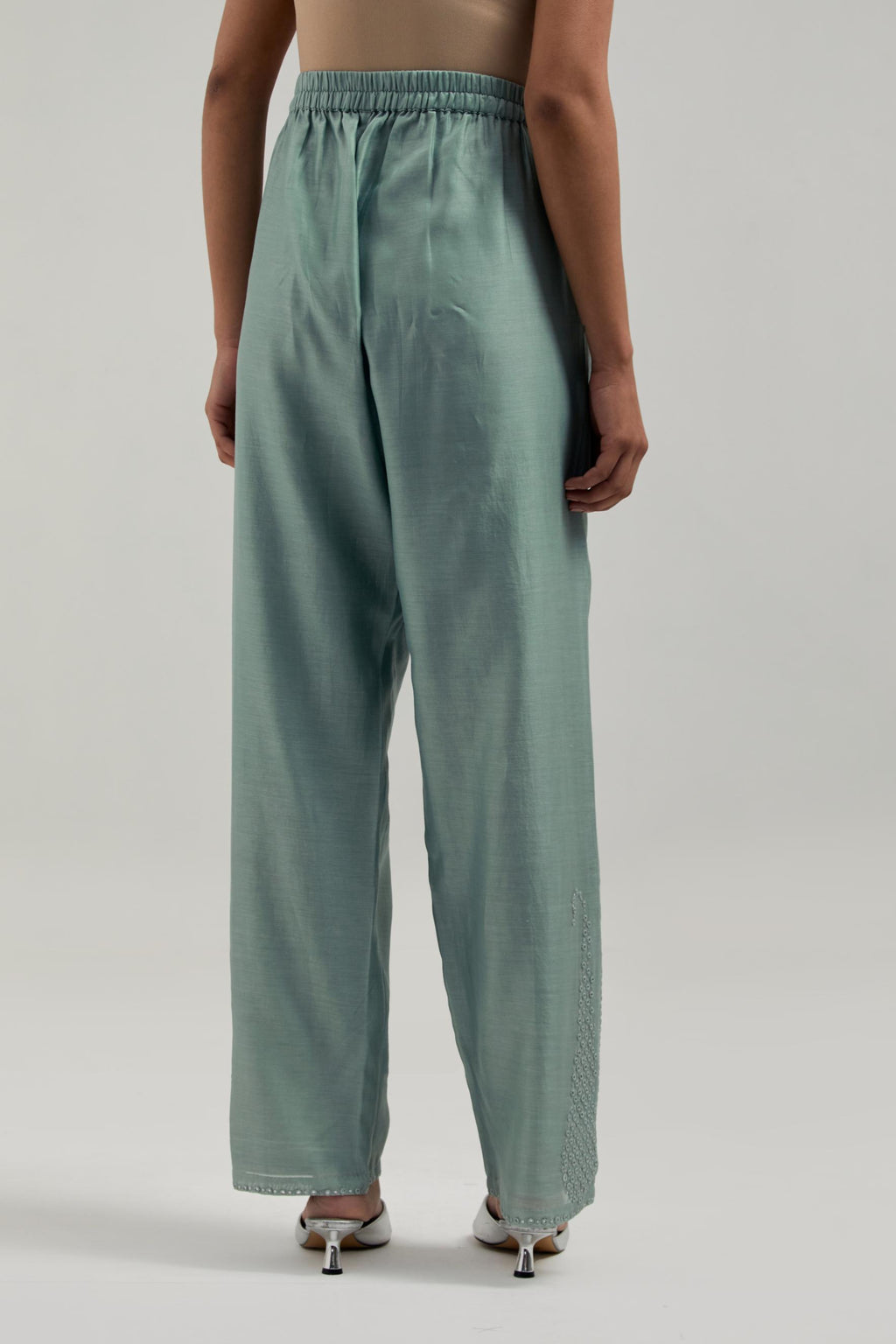 Blue silk Chanderi pants with hand-embroidered paisley motifs with delicate mirror and sequins work at the hem.