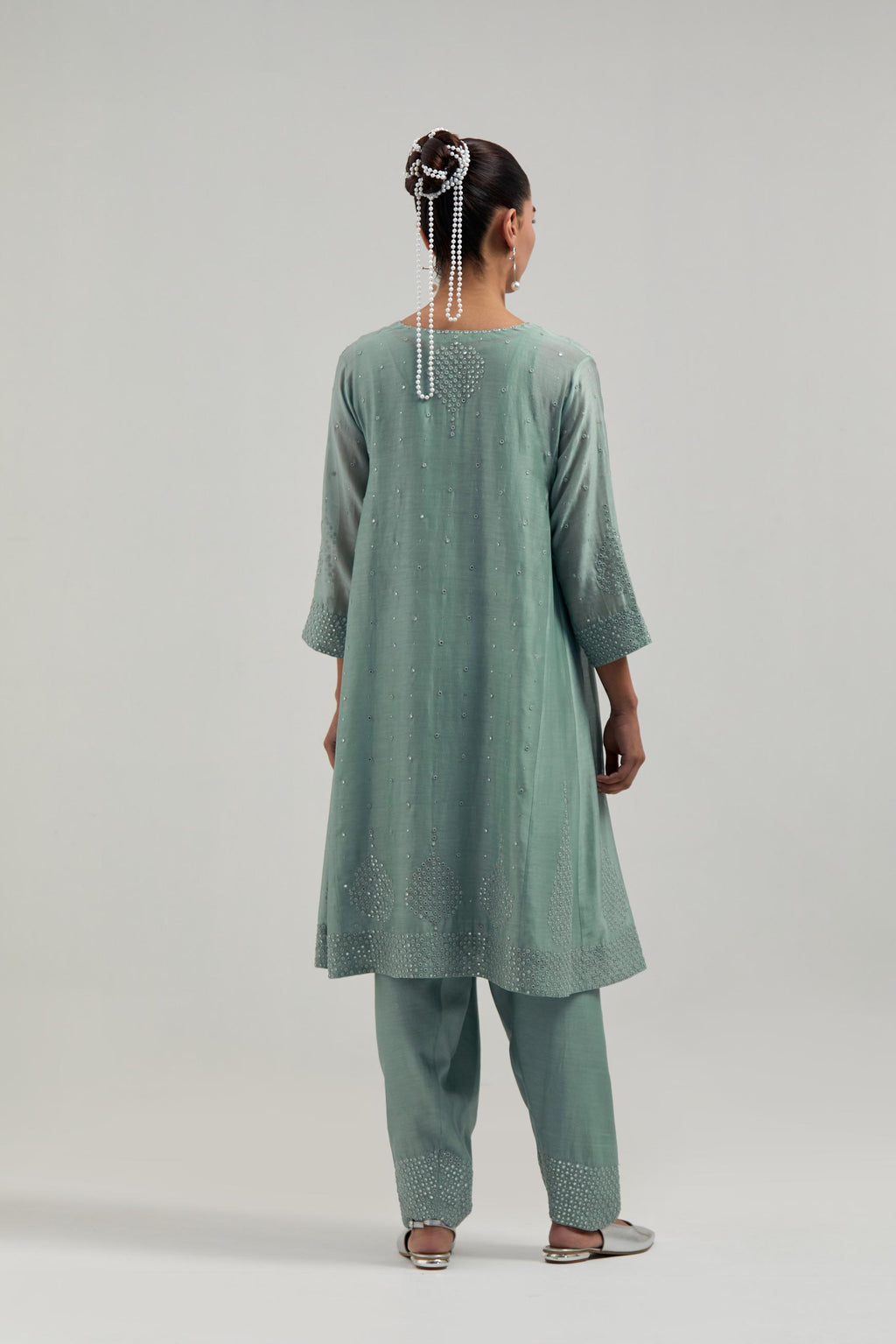 Blue silk Chanderi short kalidar kurta set, with hand embroidered mirror at neck, hem and sleeve edges, highlighted with scattered silver sequins and mirror embellishments all-over.
