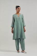 Blue silk Chanderi short kalidar kurta set, with hand embroidered mirror at neck, hem and sleeve edges, highlighted with scattered silver sequins and mirror embellishments all-over.