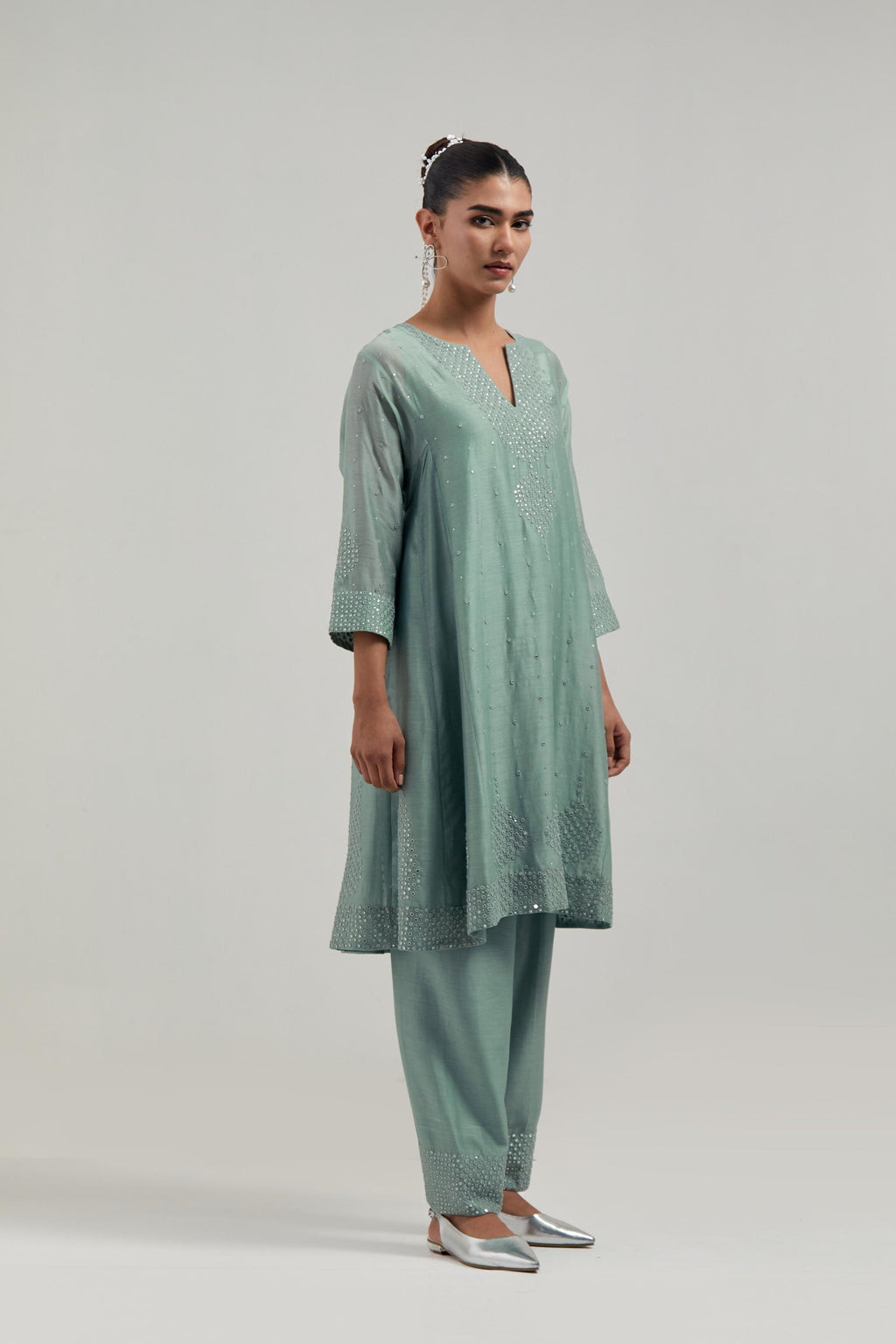 Blue silk Chanderi short kalidar kurta set, with hand embroidered mirror at neck, hem and sleeve edges, highlighted with scattered silver sequins and mirror embellishments all-over.
