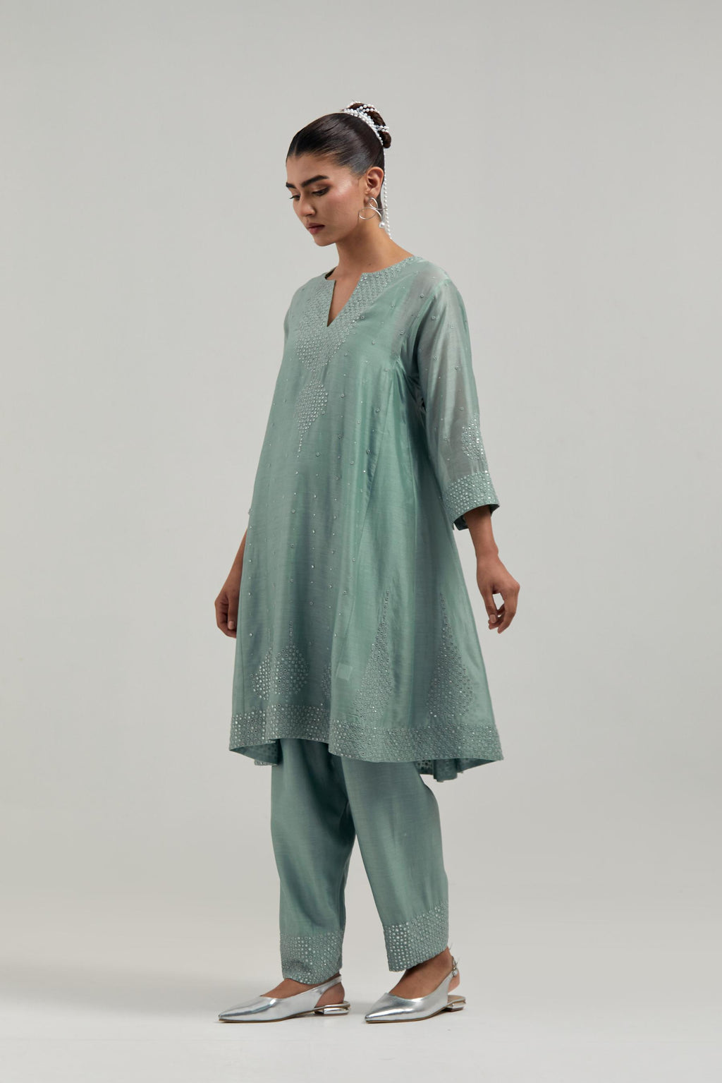 Blue silk Chanderi short kalidar kurta set, with hand embroidered mirror at neck, hem and sleeve edges, highlighted with scattered silver sequins and mirror embellishments all-over.