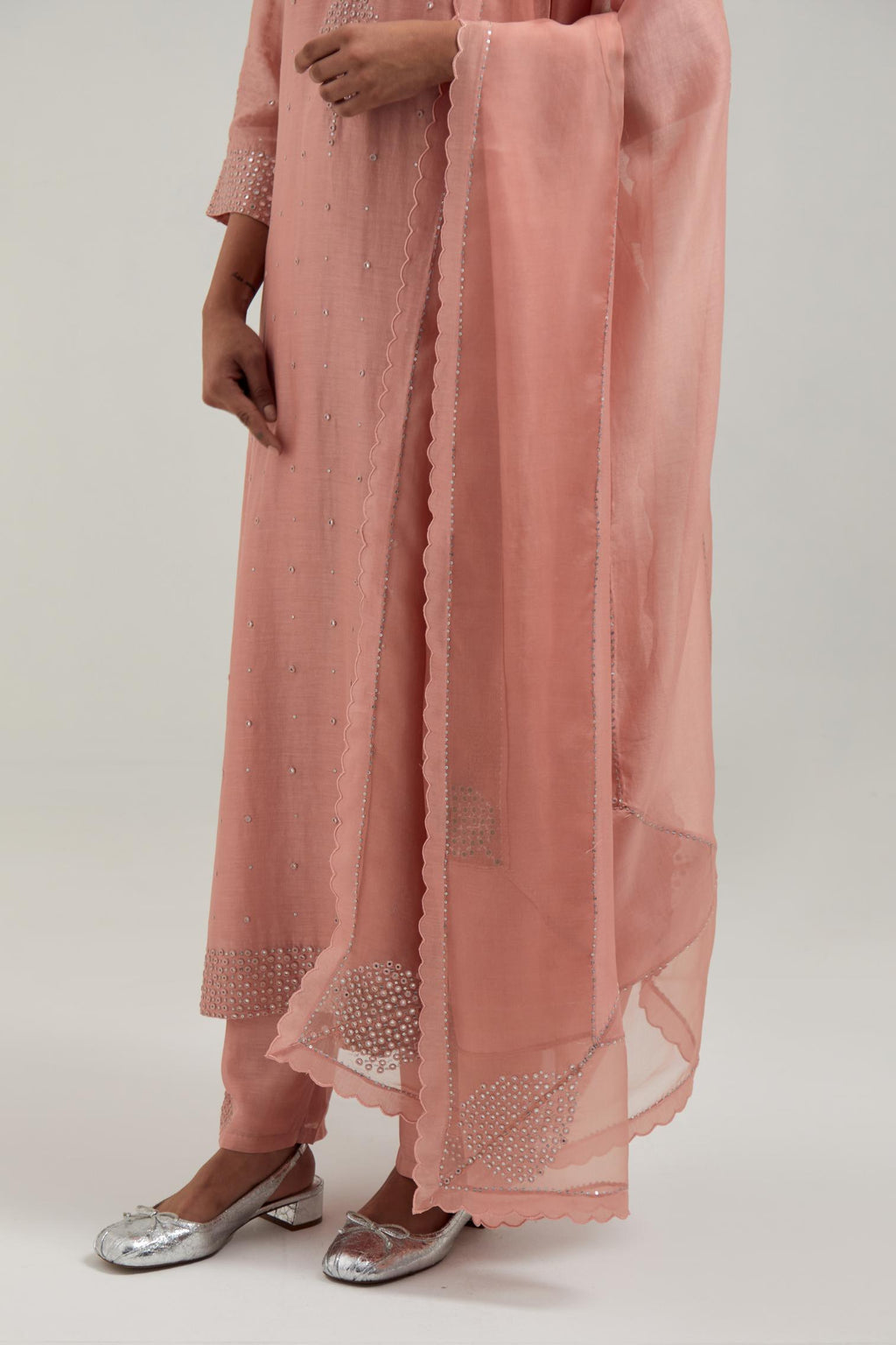 Peach silk Chanderi dupatta with silk organza at the sides, finished with delicate scalloped edges, highlighted by hand-embroidered mirror & sequins work.