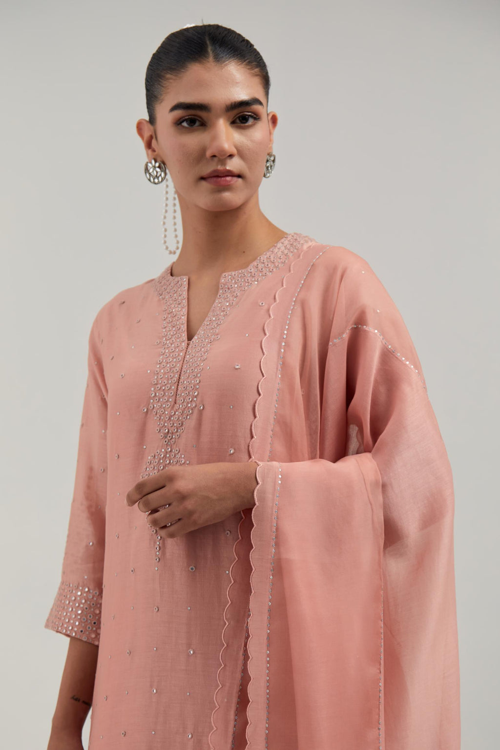 Peach silk Chanderi dupatta with silk organza at the sides, finished with delicate scalloped edges, highlighted by hand-embroidered mirror & sequins work.