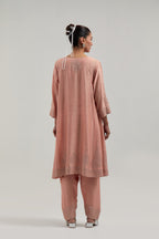 Peach silk Chanderi short kalidar kurta set, with hand embroidered mirror at neck, hem and sleeve edges, highlighted with scattered silver sequins and mirror embellishments all-over.