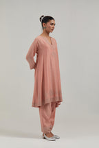 Peach silk Chanderi short kalidar kurta set, with hand embroidered mirror at neck, hem and sleeve edges, highlighted with scattered silver sequins and mirror embellishments all-over.