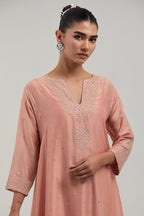 Peach silk Chanderi short kalidar kurta set, with hand embroidered mirror at neck, hem and sleeve edges, highlighted with scattered silver sequins and mirror embellishments all-over.