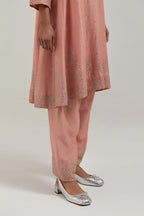 Peach silk Chanderi short kalidar kurta set, with hand embroidered mirror at neck, hem and sleeve edges, highlighted with scattered silver sequins and mirror embellishments all-over.