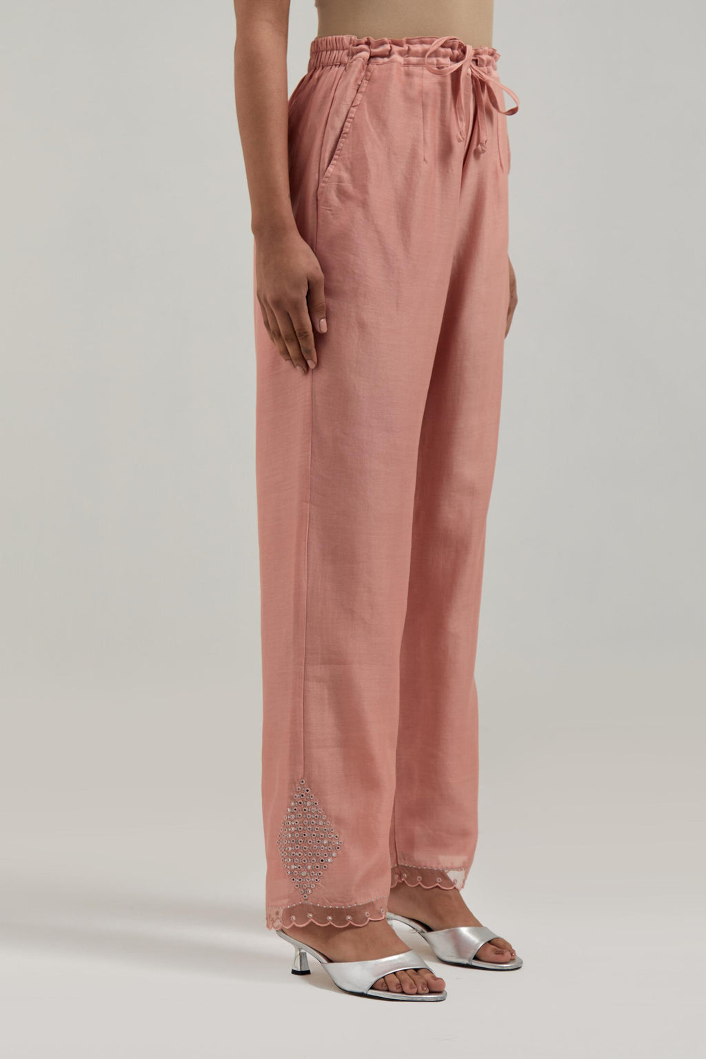 Peach silk Chanderi straight pants with narrow organza scalloped hem and hand-embroidered diamond motifs with delicate mirror & sequins work at the sides.