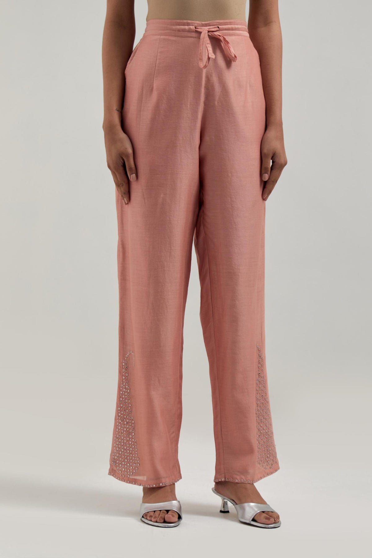 Peach silk Chanderi pants with hand-embroidered paisley motifs with delicate mirror and sequins work at the hem.