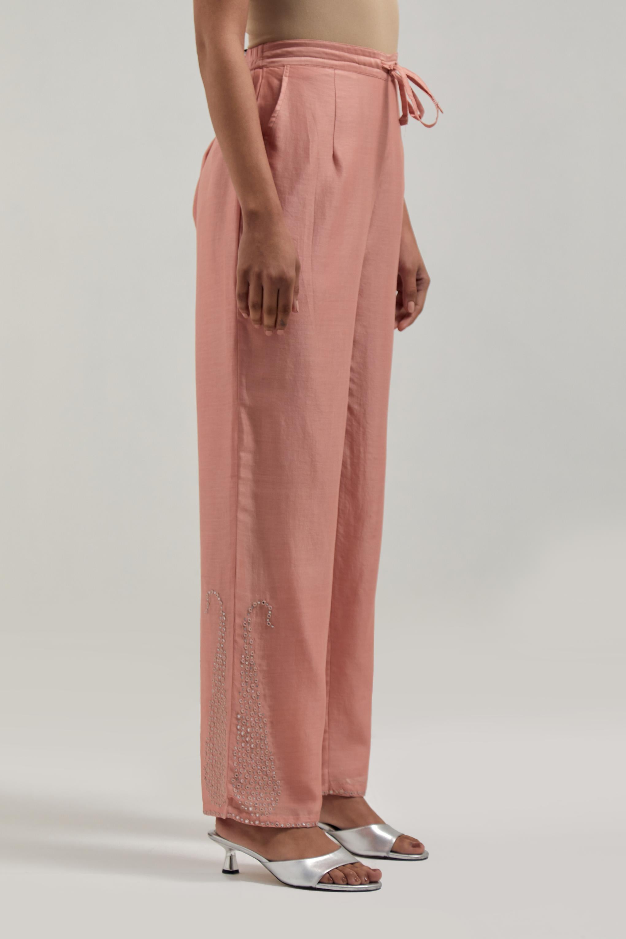 Peach silk Chanderi pants with hand-embroidered paisley motifs with delicate mirror and sequins work at the hem.