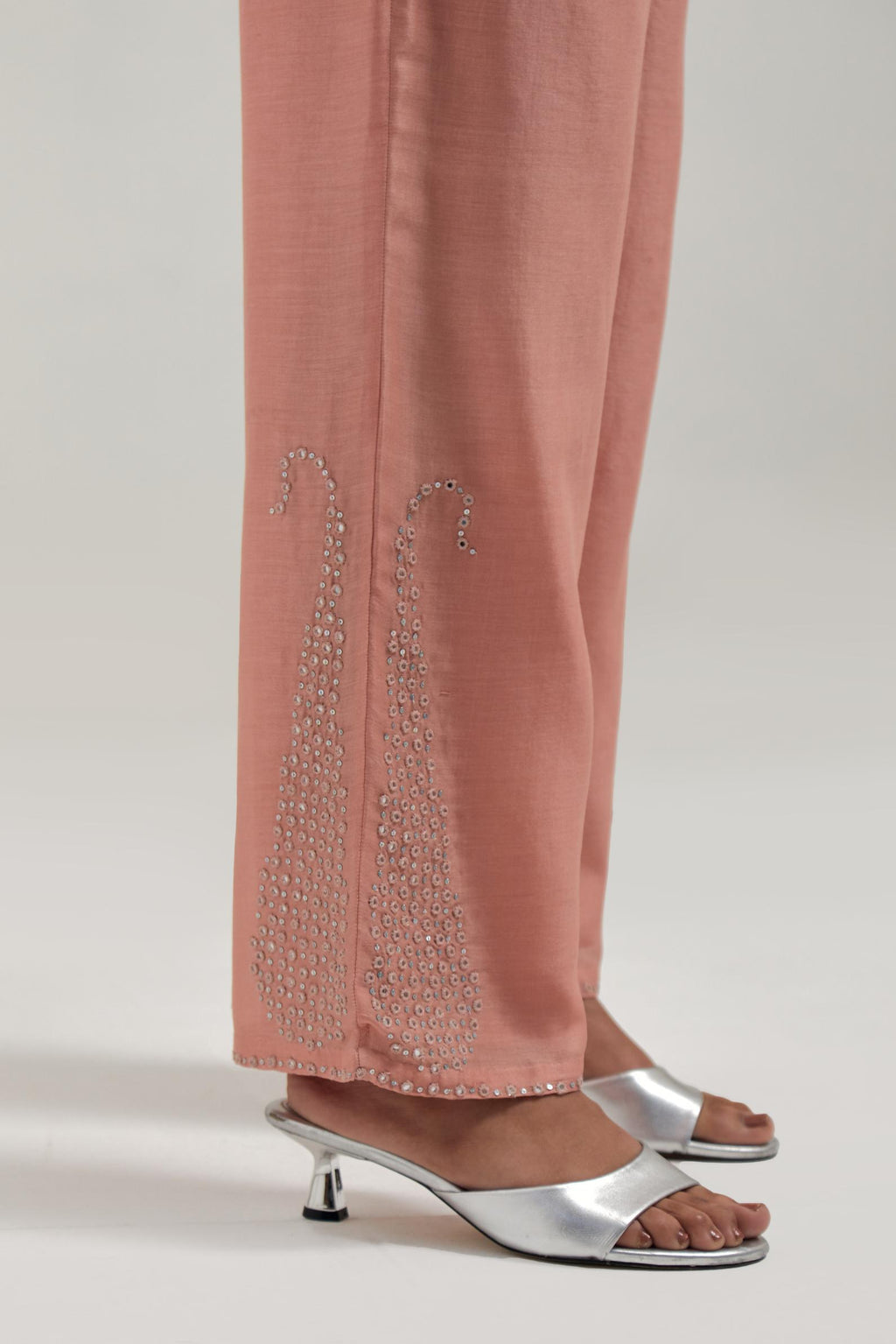 Peach silk Chanderi pants with hand-embroidered paisley motifs with delicate mirror and sequins work at the hem.