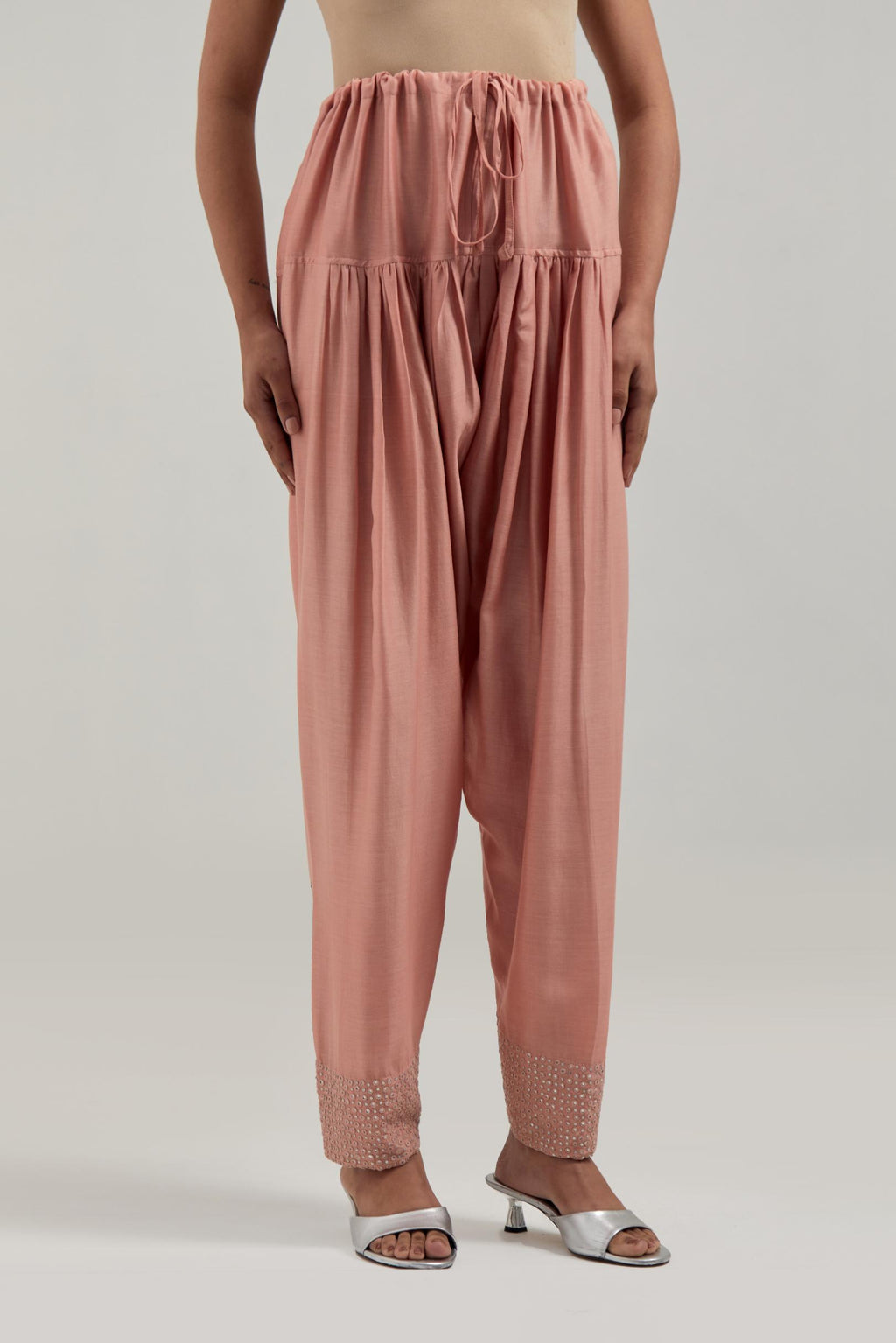 Peach silk Chanderi salwar with hand-embroidered mirror & sequins work in a broad border at the hem.