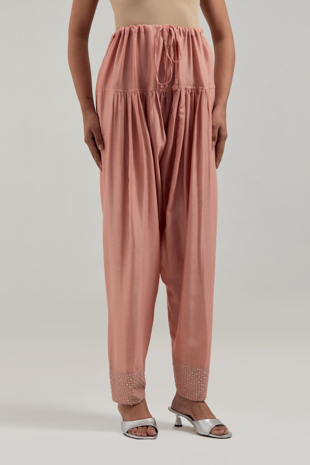 Peach silk Chanderi salwar with hand-embroidered mirror & sequins work in a broad border at the hem.