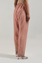 Peach silk Chanderi salwar with hand-embroidered mirror & sequins work in a broad border at the hem.