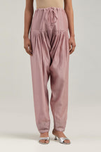 Pink silk Chanderi salwar with hand-embroidered mirror & sequins work in a broad border at the hem.
