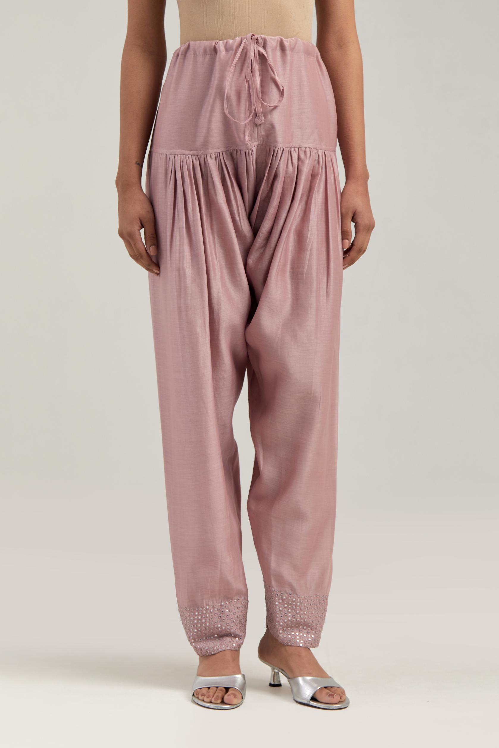 Pink silk Chanderi salwar with hand-embroidered mirror & sequins work in a broad border at the hem.