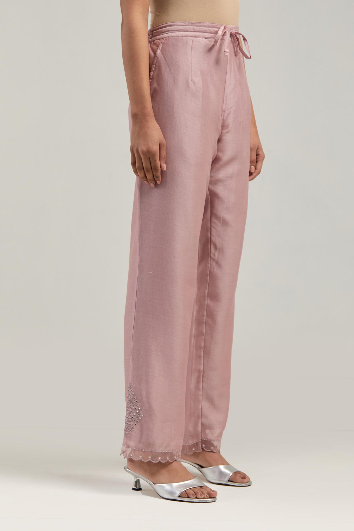 Pink silk Chanderi straight pants with narrow organza scalloped hem and hand-embroidered diamond motifs with delicate mirror & sequins work at the sides.