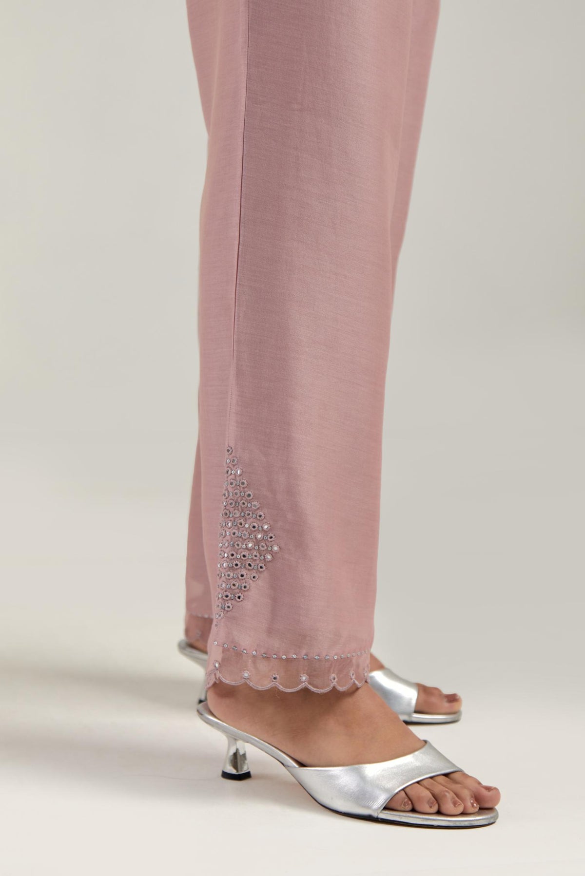 Pink silk Chanderi straight pants with narrow organza scalloped hem and hand-embroidered diamond motifs with delicate mirror & sequins work at the sides.
