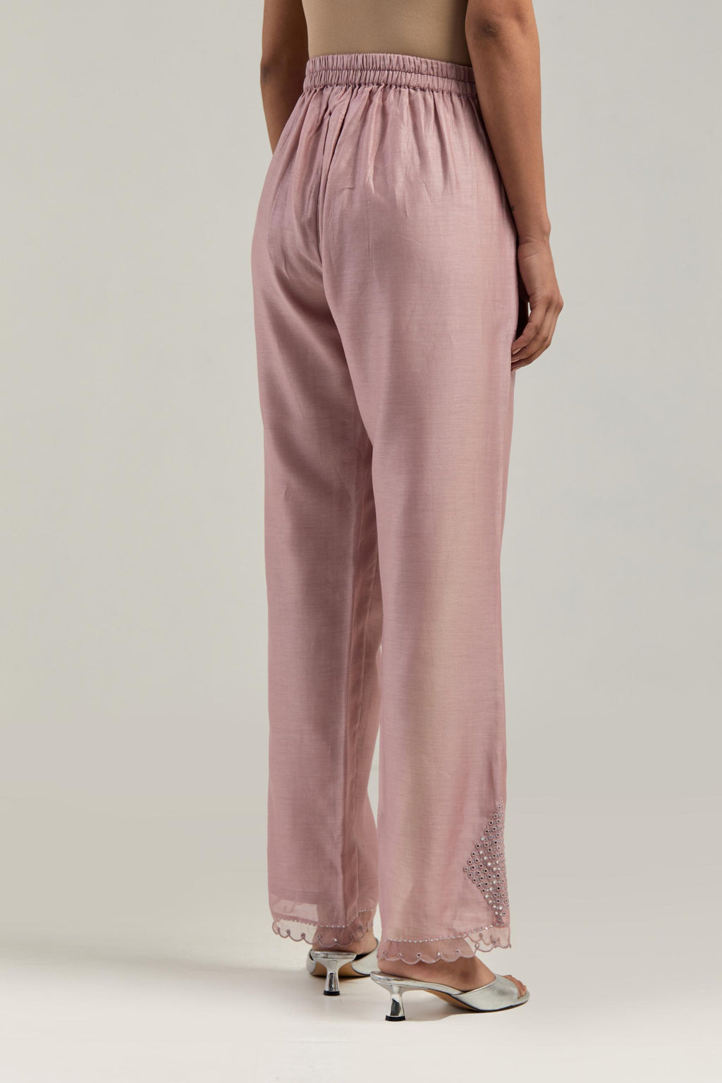Pink silk Chanderi straight pants with narrow organza scalloped hem and hand-embroidered diamond motifs with delicate mirror & sequins work at the sides.