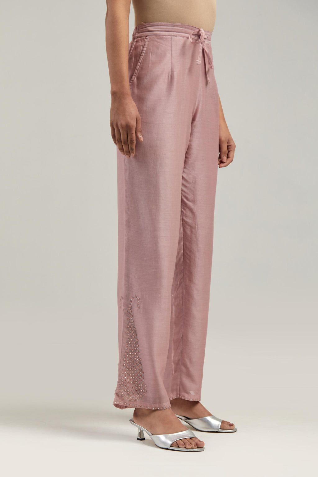 Pink silk Chanderi pants with hand-embroidered paisley motifs with delicate mirror and sequins work at the hem.