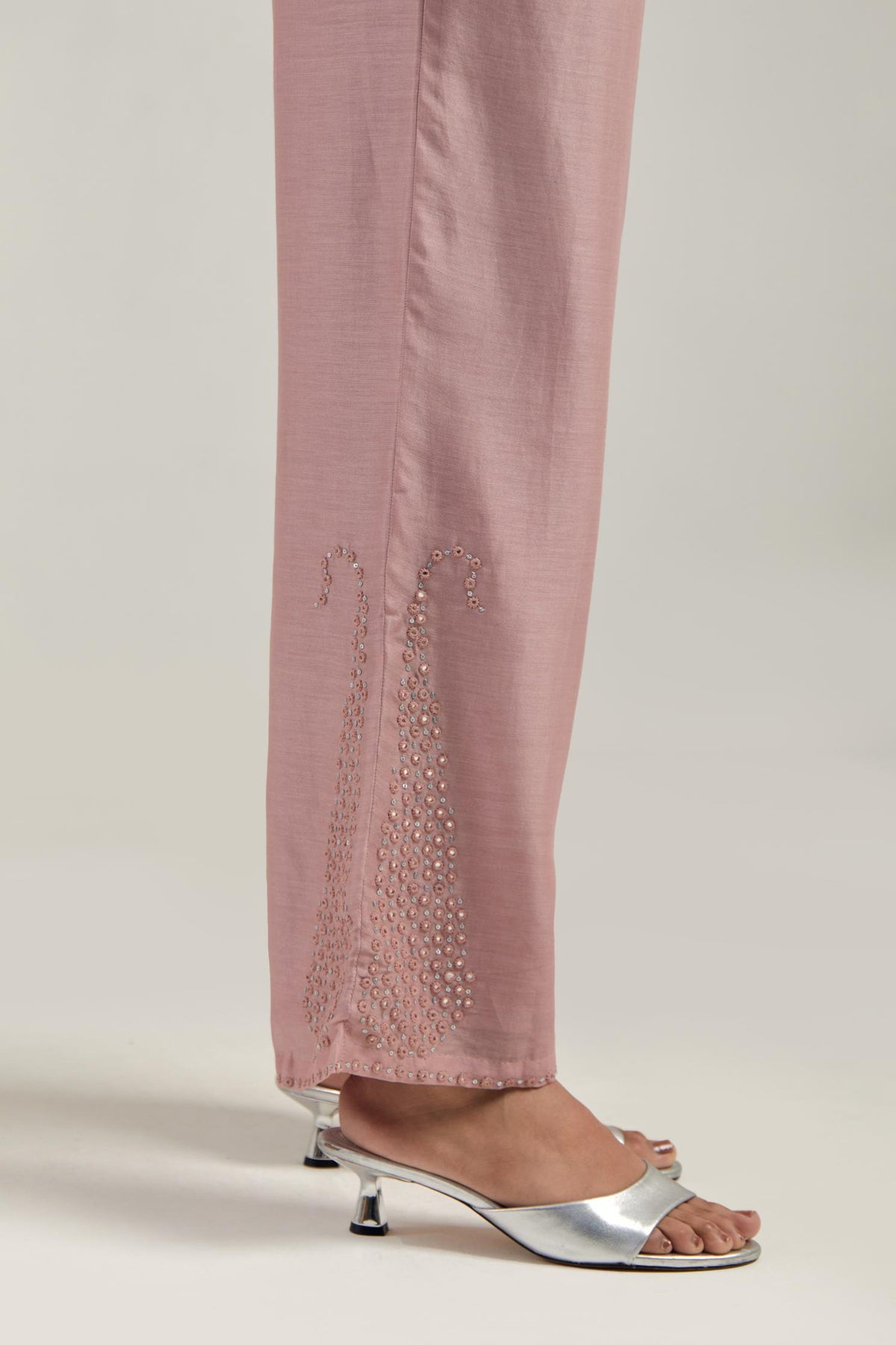 Pink silk Chanderi pants with hand-embroidered paisley motifs with delicate mirror and sequins work at the hem.