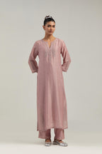 Pink silk Chanderi straight kurta set with hand-embroidered paisley motifs with delicate mirror and sequins work at neck, hem, and sleeves, with narrow borders along the edges.