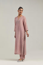 Pink silk Chanderi straight kurta set with hand-embroidered paisley motifs with delicate mirror and sequins work at neck, hem, and sleeves, with narrow borders along the edges.