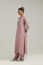 Pink silk Chanderi straight kurta set with hand-embroidered mirror at the neck, hem and sleeves, highlighted with scattered silver sequin and mirror embellishments all-over.