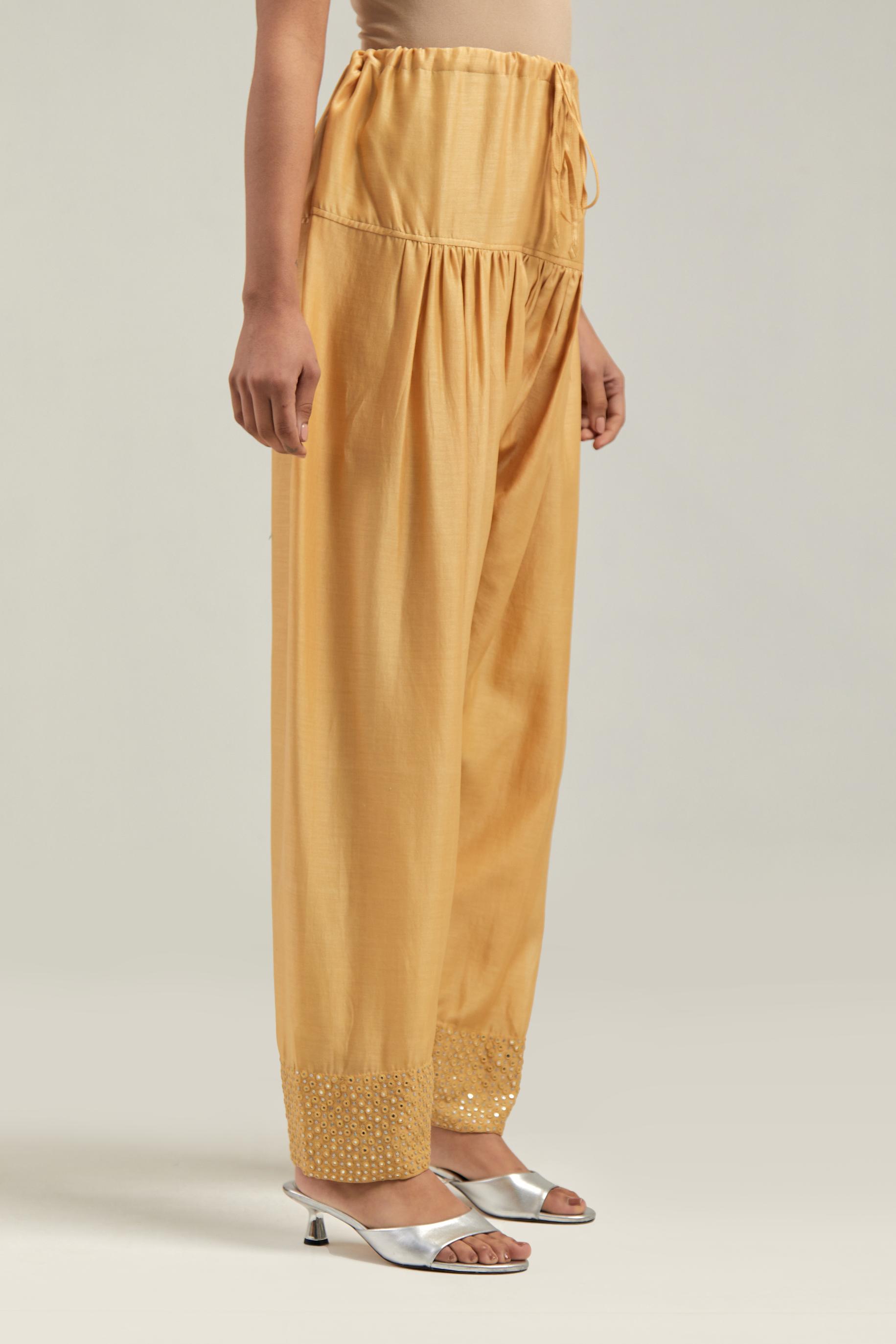 Yellow silk Chanderi salwar with hand-embroidered mirror & sequins work in a broad border at the hem.